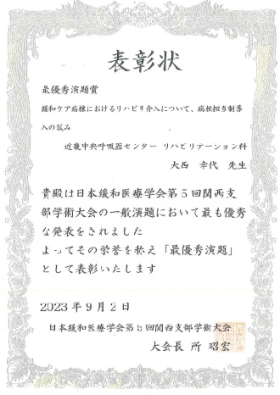 最優秀演題賞の賞状を持った写真